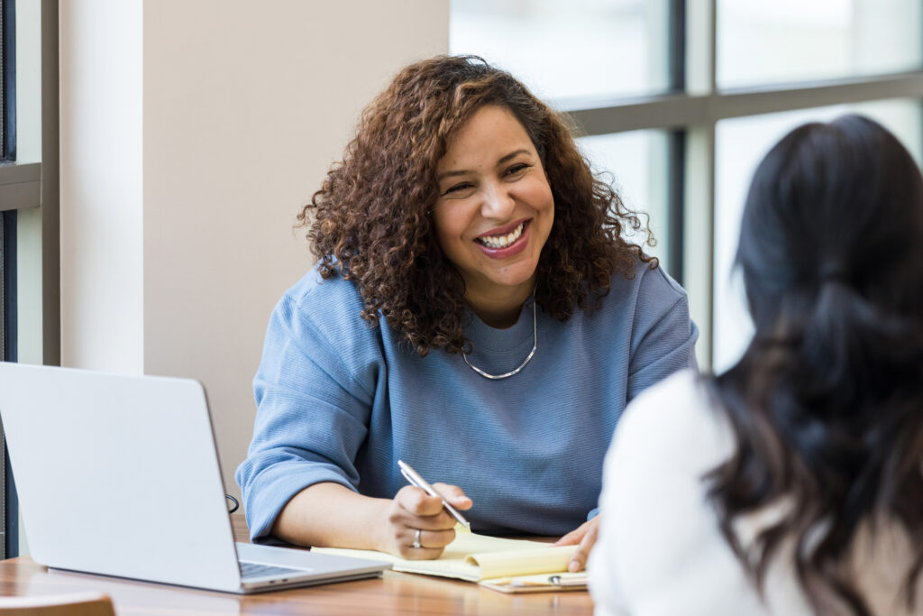 Mature businesswoman smiles encouragingly at female employee